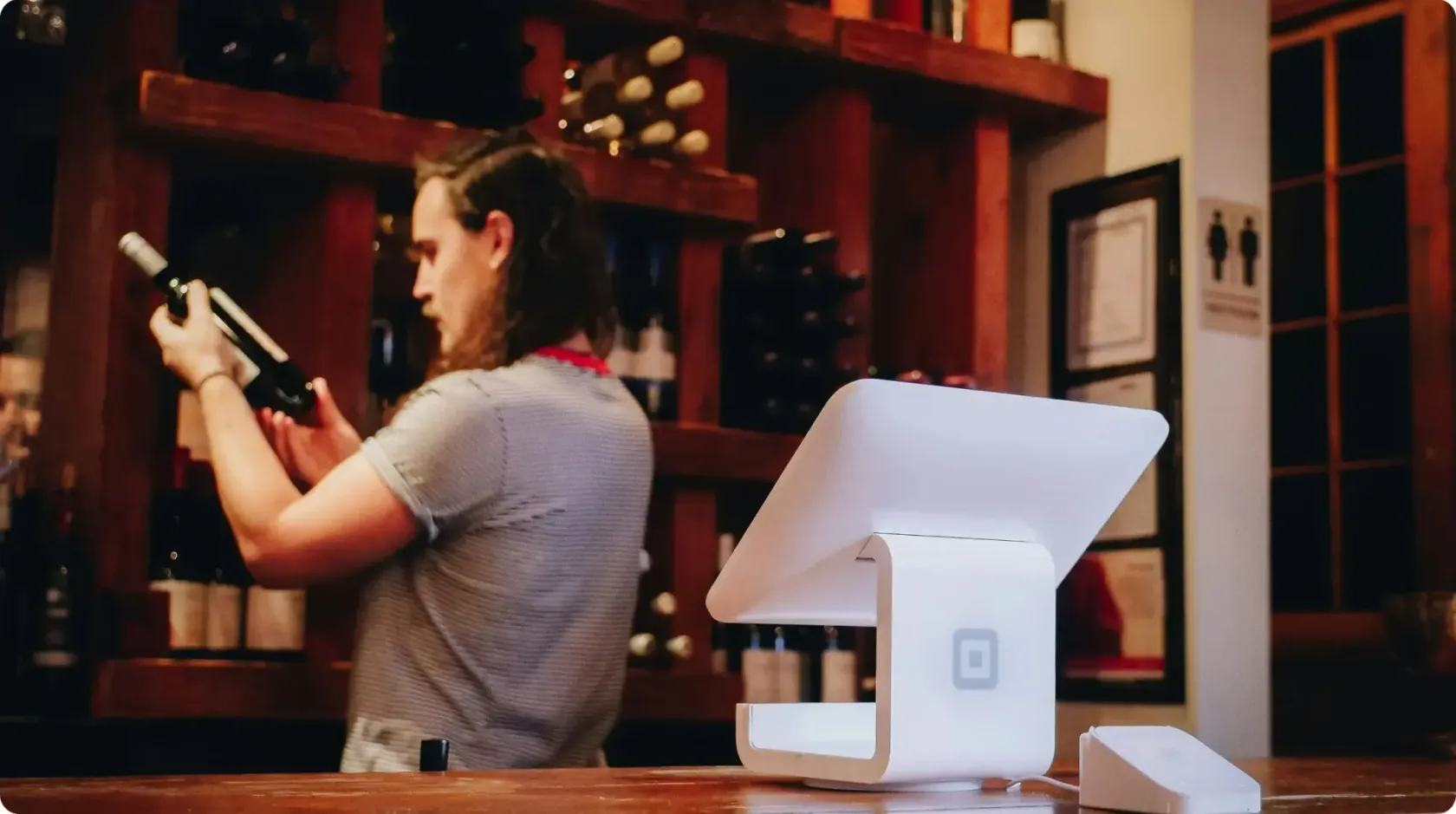 Barman Checking Wine Bottles In Bar