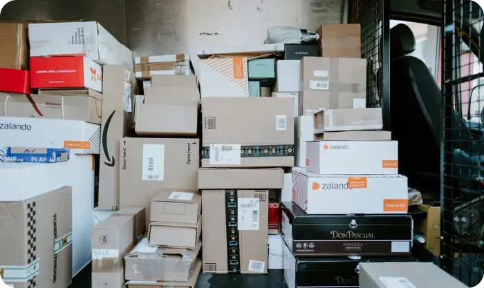 Stacked cardboard parcels piled inside a delivery van