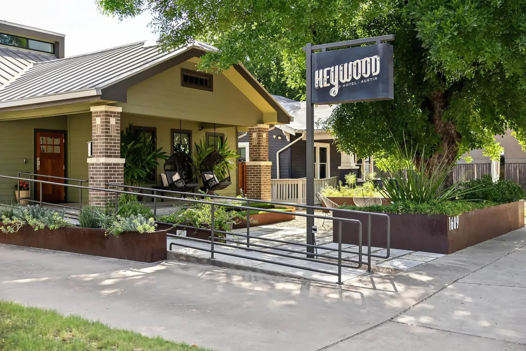 Entrance of the Heywood Hotel in Austin with its sign, planters and covered porch