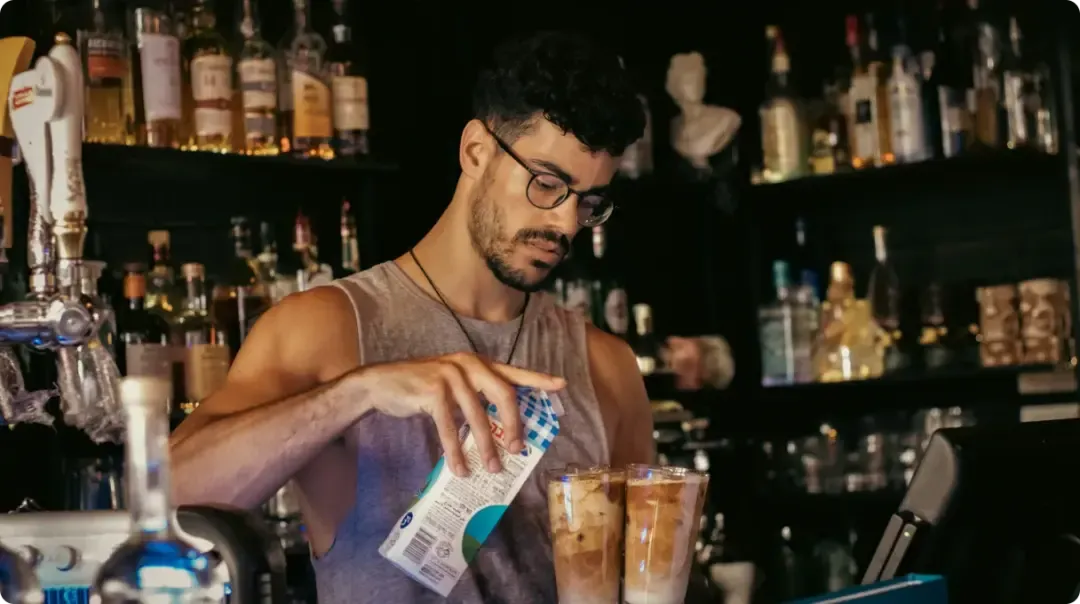 Man Adding Milk To Coffee