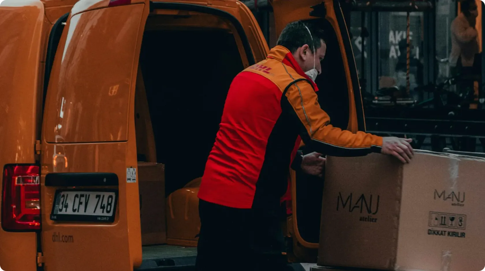 Man In Red Jacket Standing Beside Orange Van