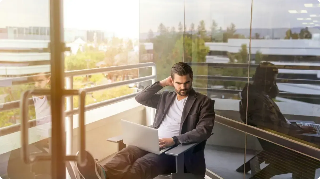 Man Working On Laptop On Office Balcony