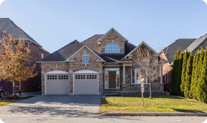 Brick suburban house with a two-car garage and a front lawn