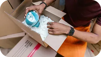 Person Packing Mug In Box With Cushioning Mobile