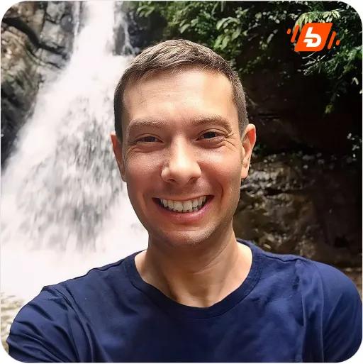  Adam Riemer is on the waterfall landscape, smiling at the camera.