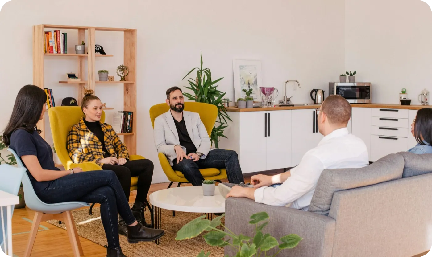 Four people meeting in a room discussing bussiness.