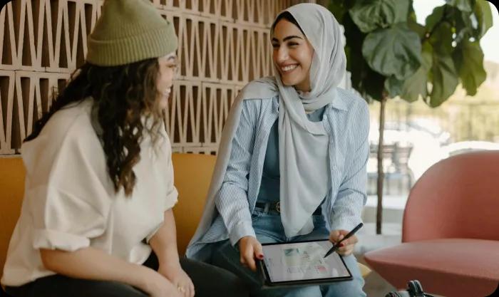 Women talking in a cafe - one of them wears hijab