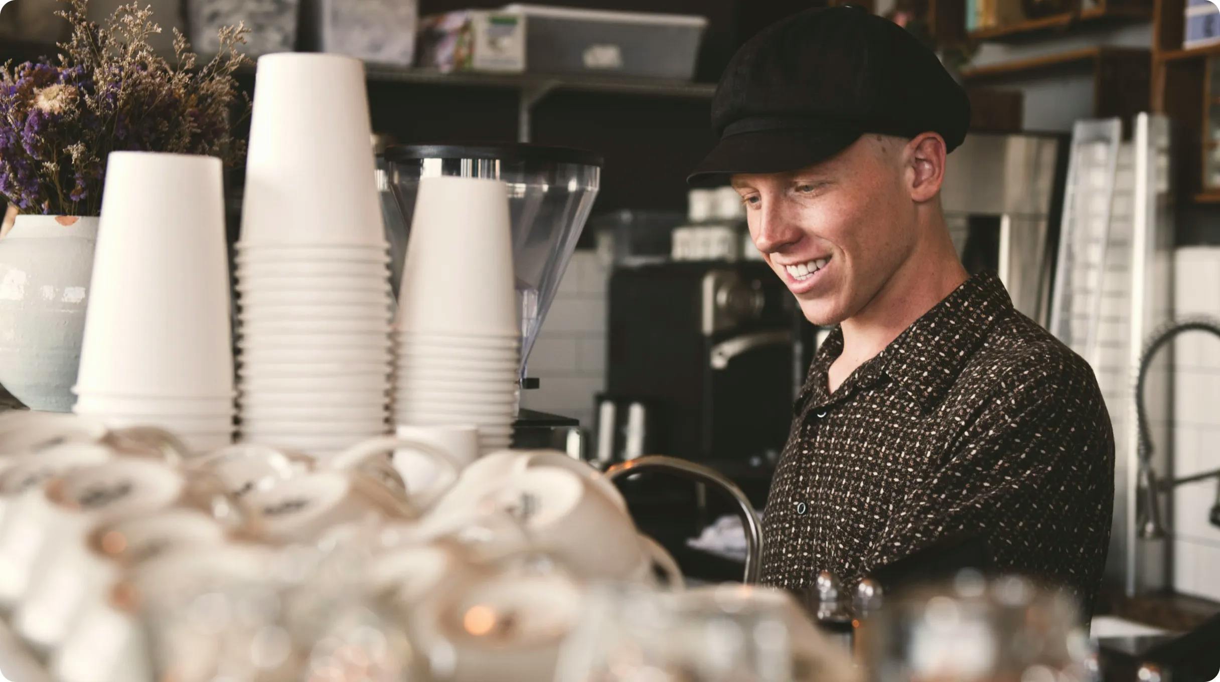 A man smiling doing his work at a coffee shop.