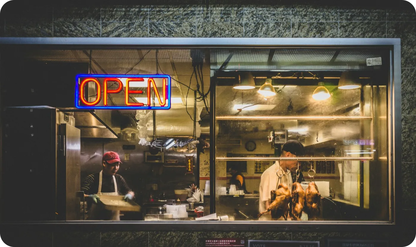 A restaurant front with a sign reading "Open" in capital letters.