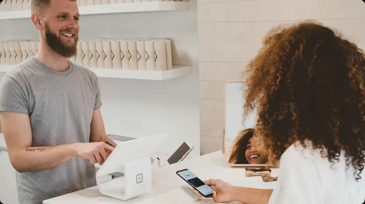 A woman paying contactless in shop