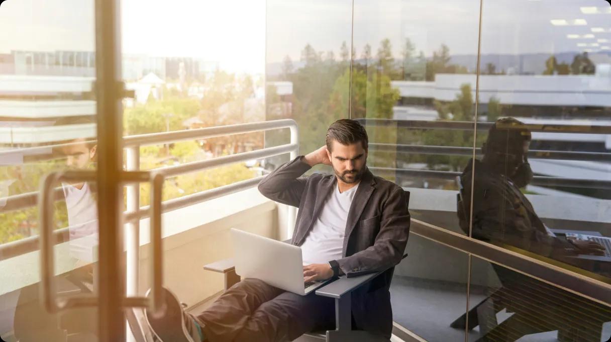 A man working with a laptop outside.