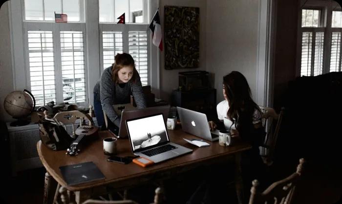 Two women engaged in work, focused on their tasks in a collaborative environment.