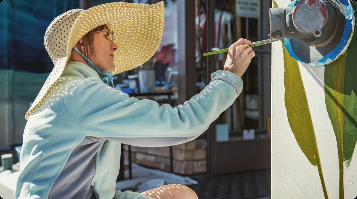 A woman painting art outside.