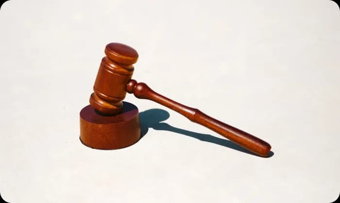 A wooden gavel rests on a clean white surface.