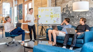 Several people collaborating at a table, each using laptops, creating a productive and interactive environment.