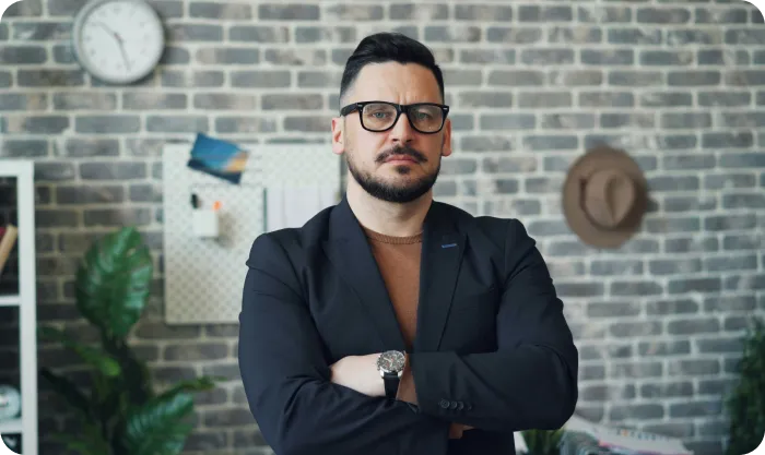 Man with glasses and beard standing in office