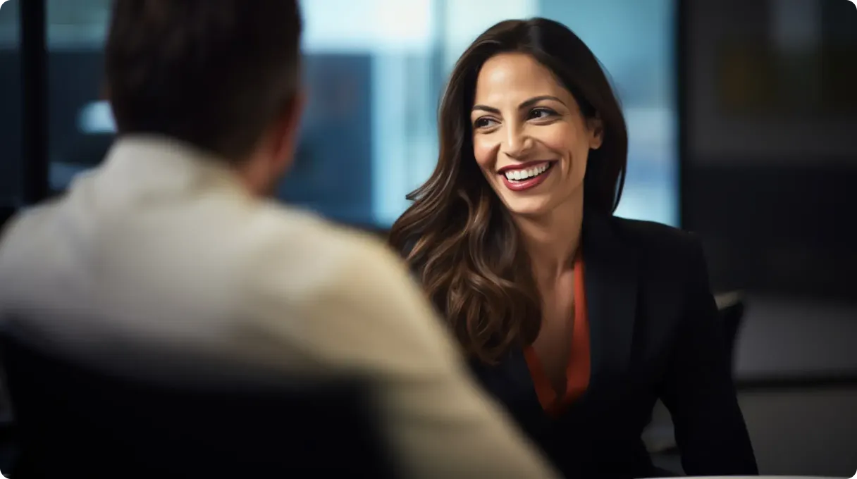 Woman sitting and smiling in front of a man
