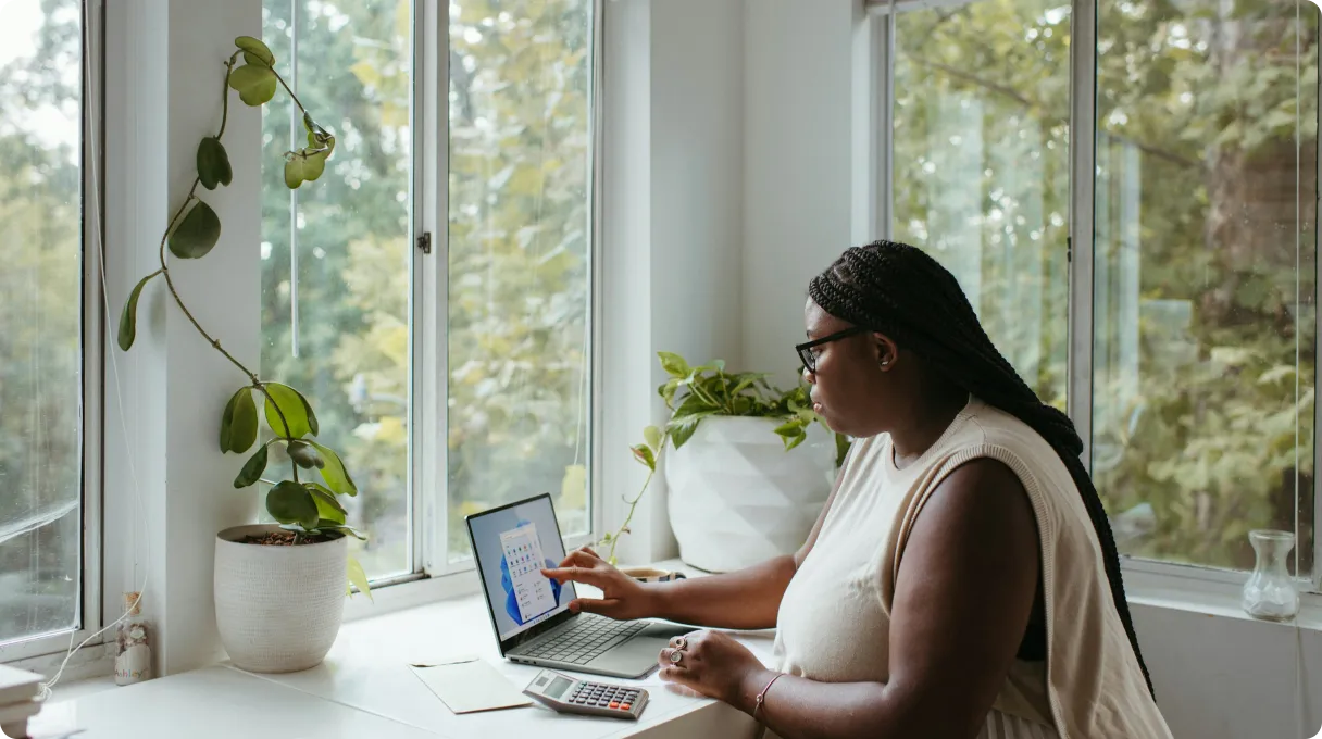 Woman sitting at a desk with laptop and calculator