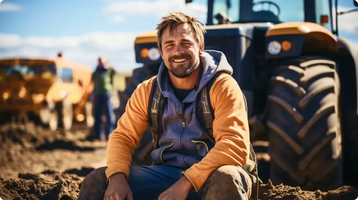 Worker in orange blue hoodie sitting in front of a machine
