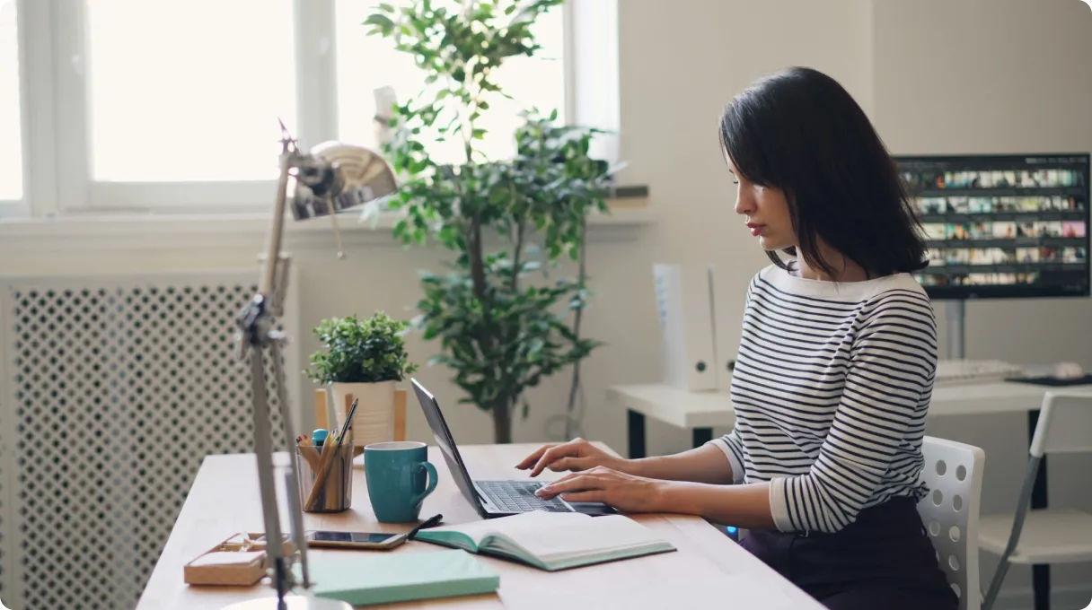 A woman sitting at a desk using a laptop computer