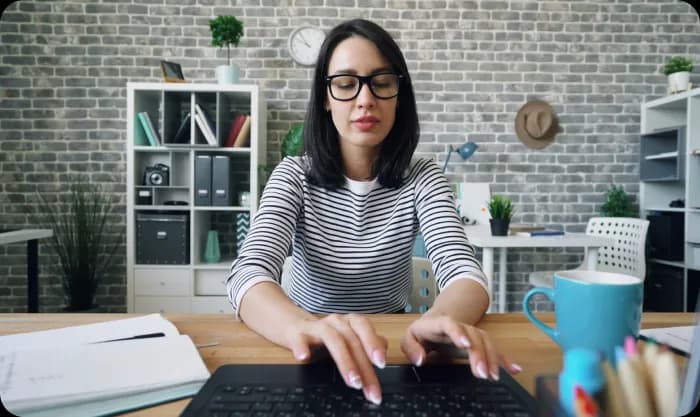A woman sitting at a desk using a laptop computer