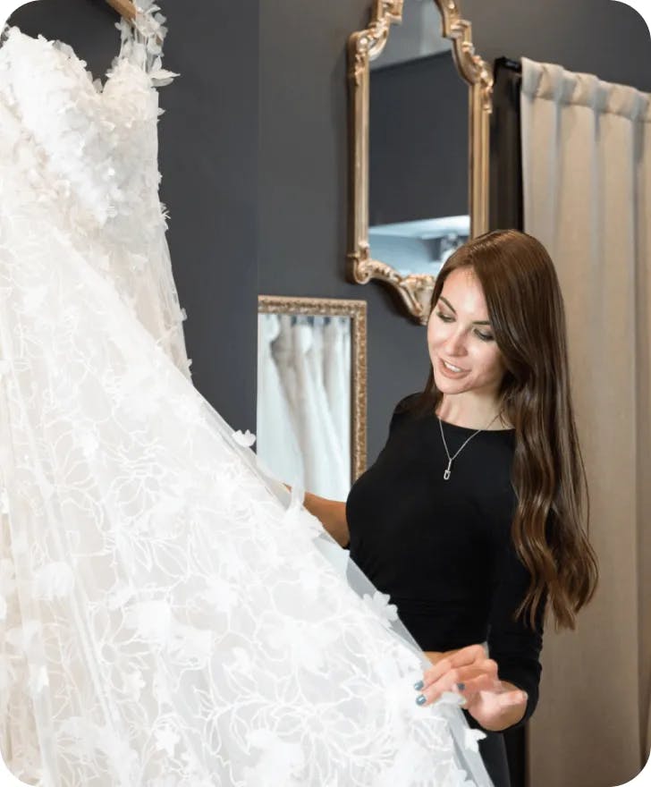 Marina Andriichenko holding a wedding dress.