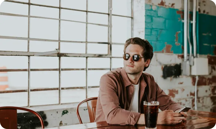 Elegant man sitting at the table with a phone in his hands