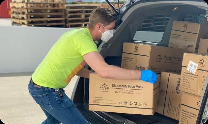 man-in-green-t-shirt-and-blue-denim-jeans-holding-brown-cardboard-box