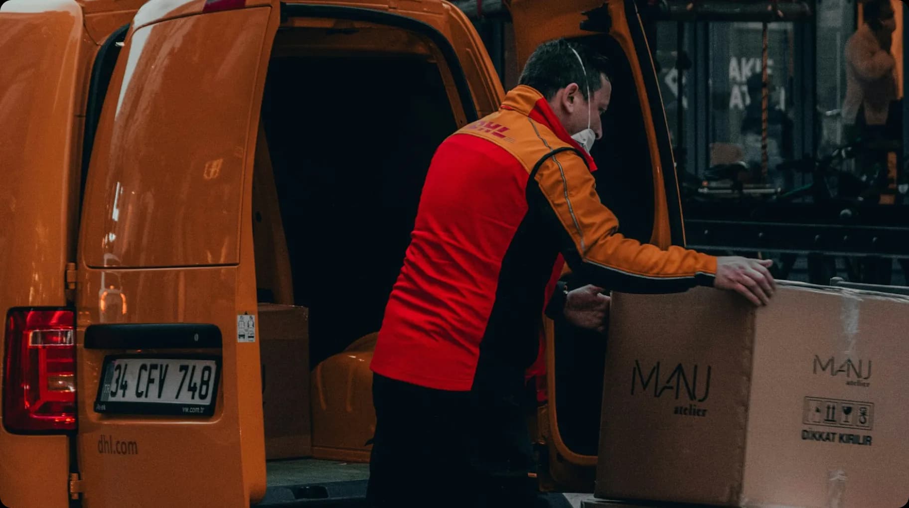 man-in-red-jacket-standing-beside-orange-van-during-daytime