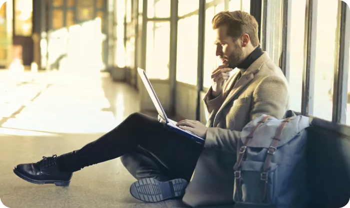 Man sitting on floor while using laptop