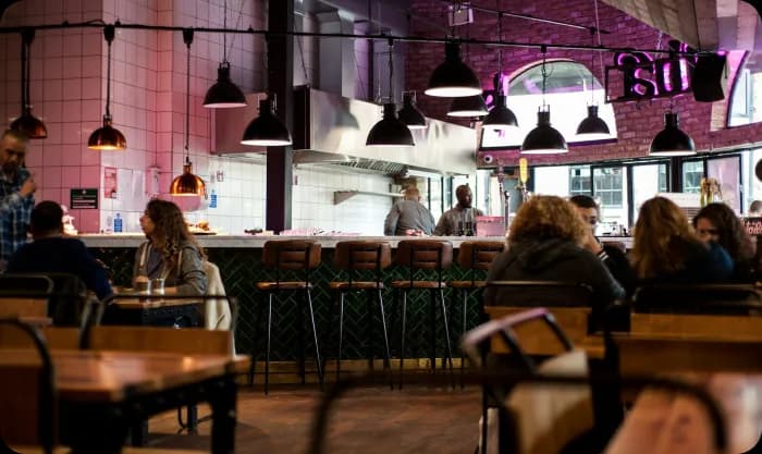 people-sitting-inside-and-others-are-standing-in-restaurant