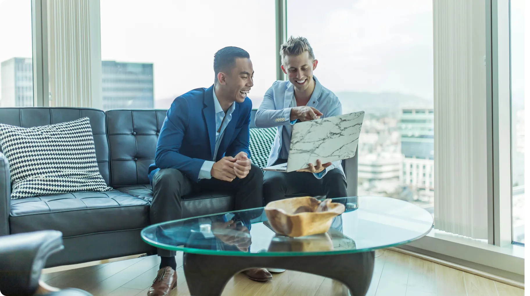 two-men-sitting-on-a-couch-beside-a-table