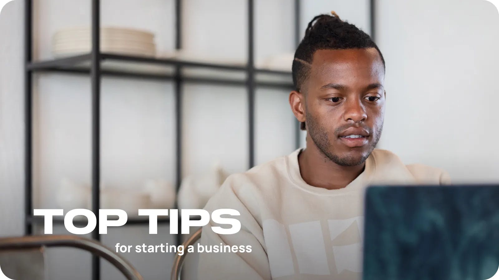 Danilo Batson sitting with the computer. Title: Top Tips for starting a business