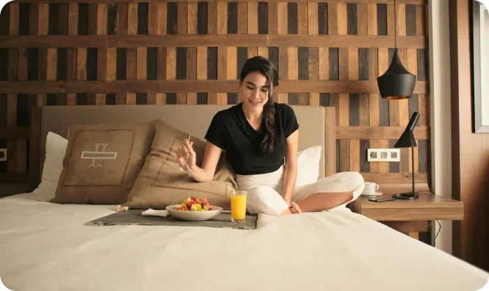woman-enjoying-breakfast-in-cozy-hotel-room