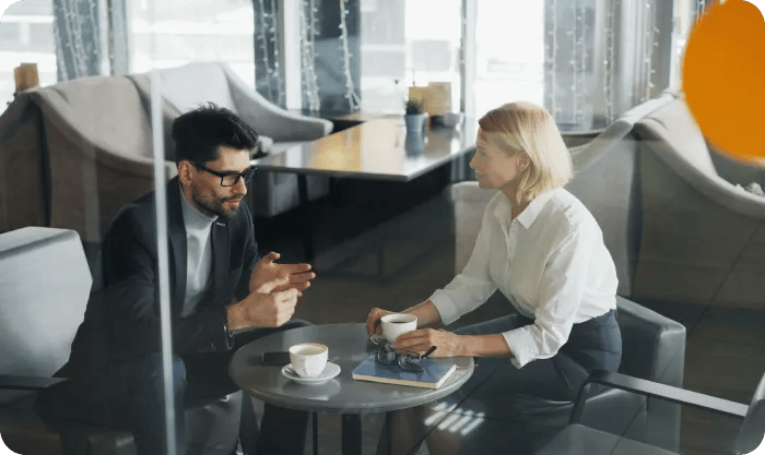 A Man And A Woman Sitting At A Table Xtktmcua Dw