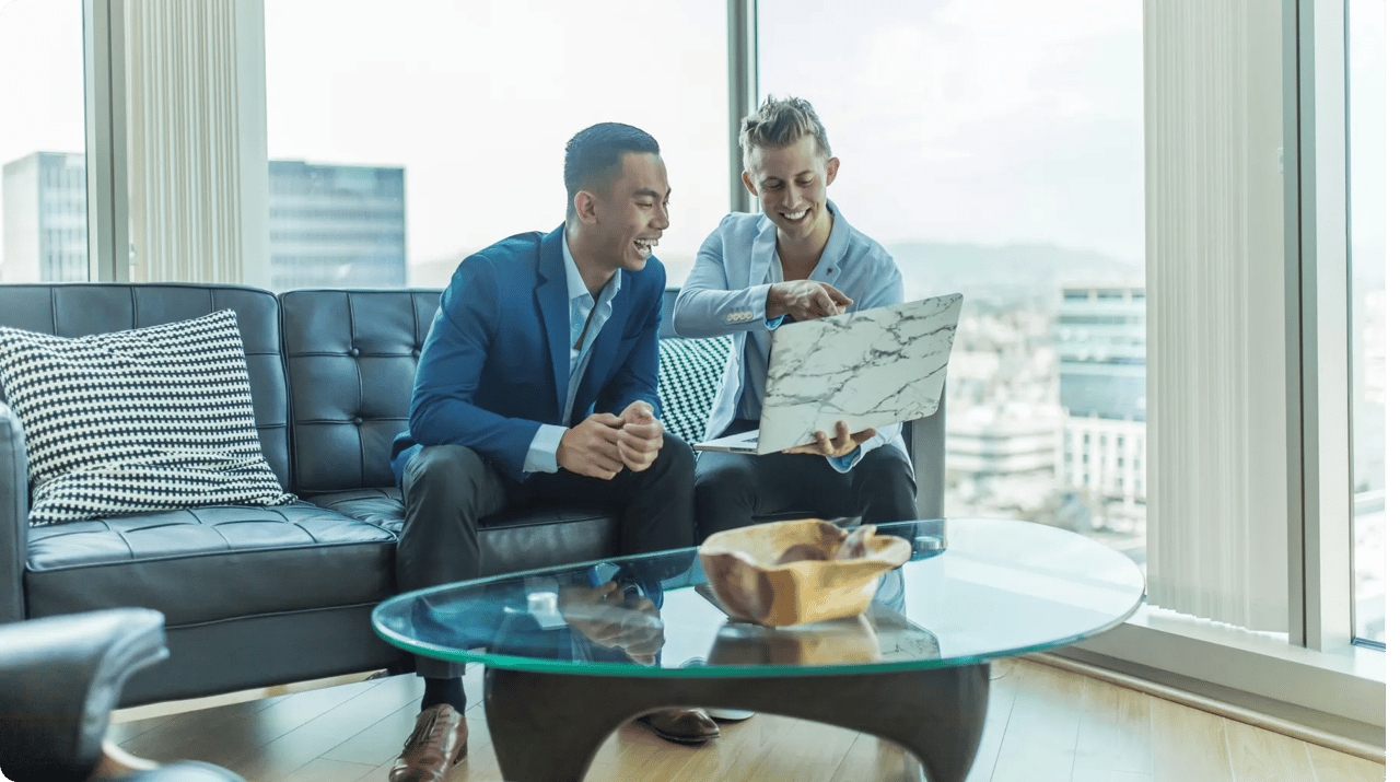 Two Men Sitting On A Couch Beside A Table