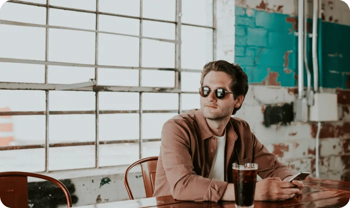 Guy Sitting At The Table With Phone ARTICLE