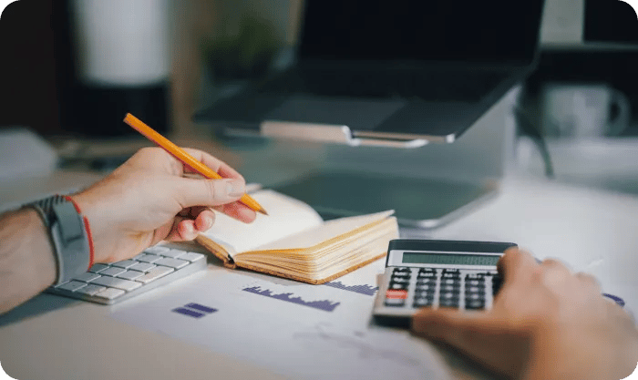 Man Using Calculator And Taking Notes