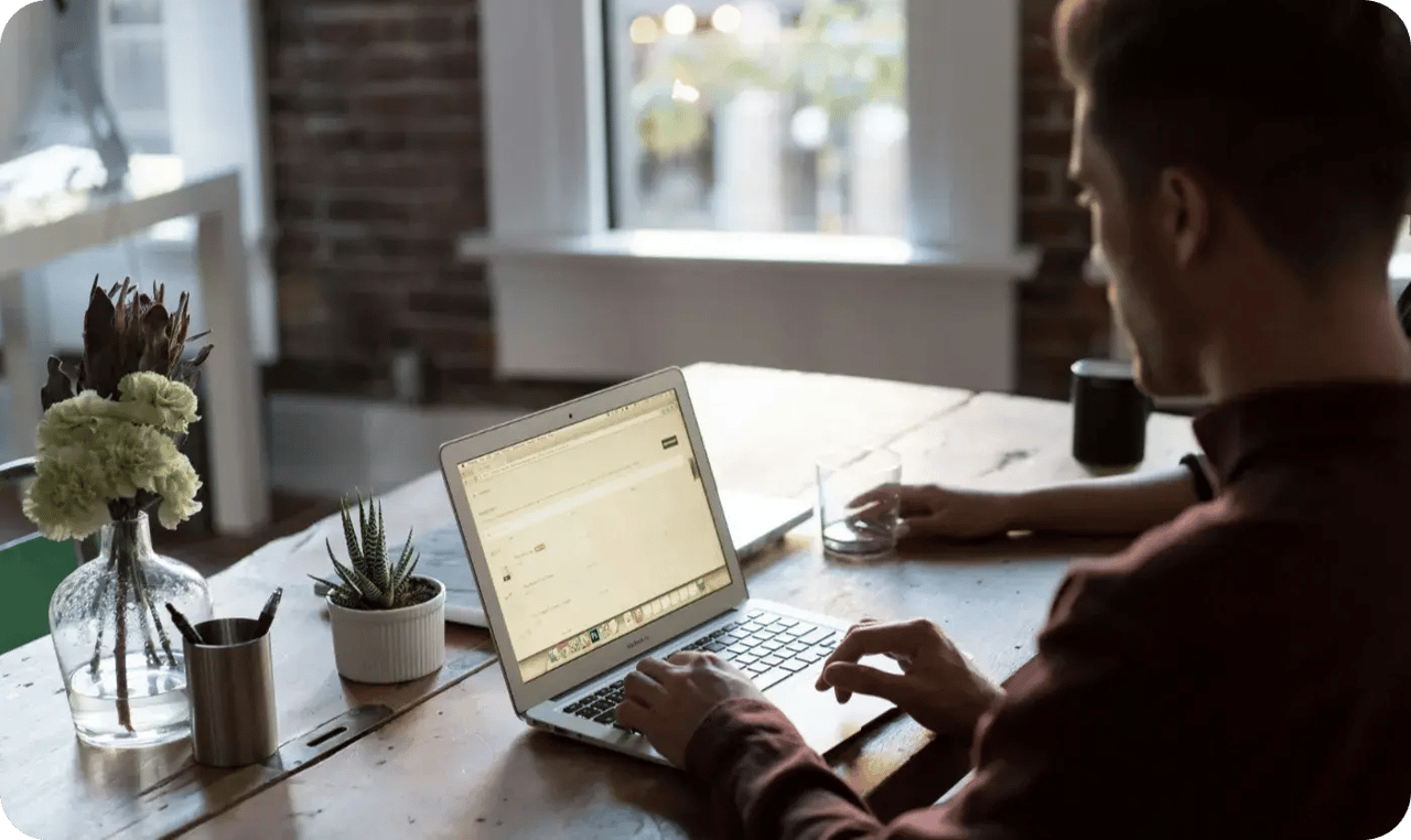 Person Working On Laptop At Home Office Table
