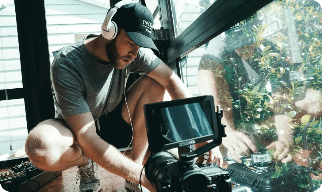 Filmmaker Recording Audio With Headphones And Camera
