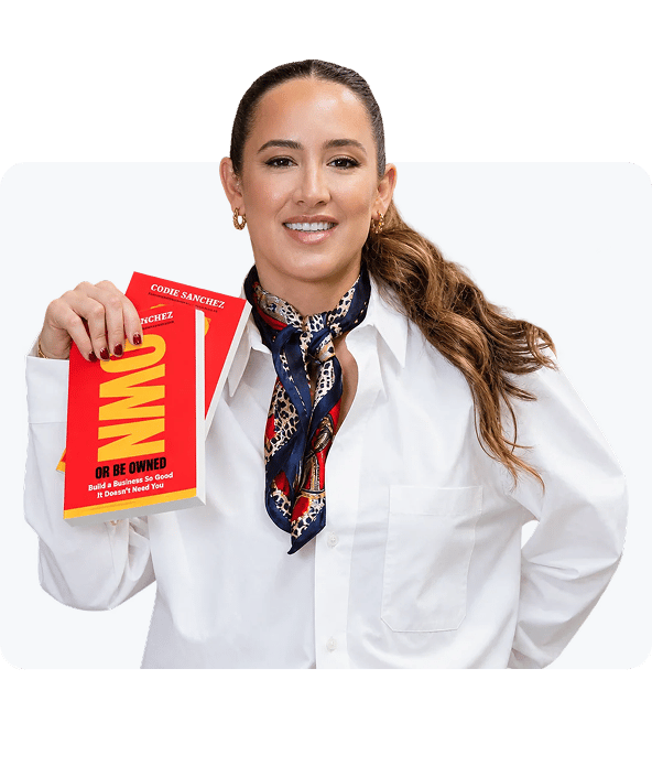 Codie Sanchez in a white shirt and scarf, holding a copy of her book Own or Be Owned