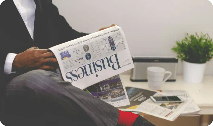 Person Sitting Near Table Holding Newspaper Rfufqjekzfy