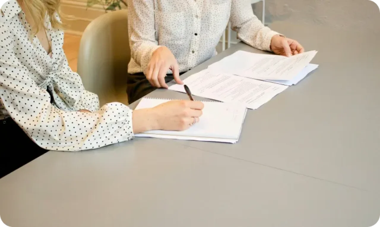 Woman Signing On White Printer Paper Beside Woman About To Touch The Documents Hjckknwcxxq