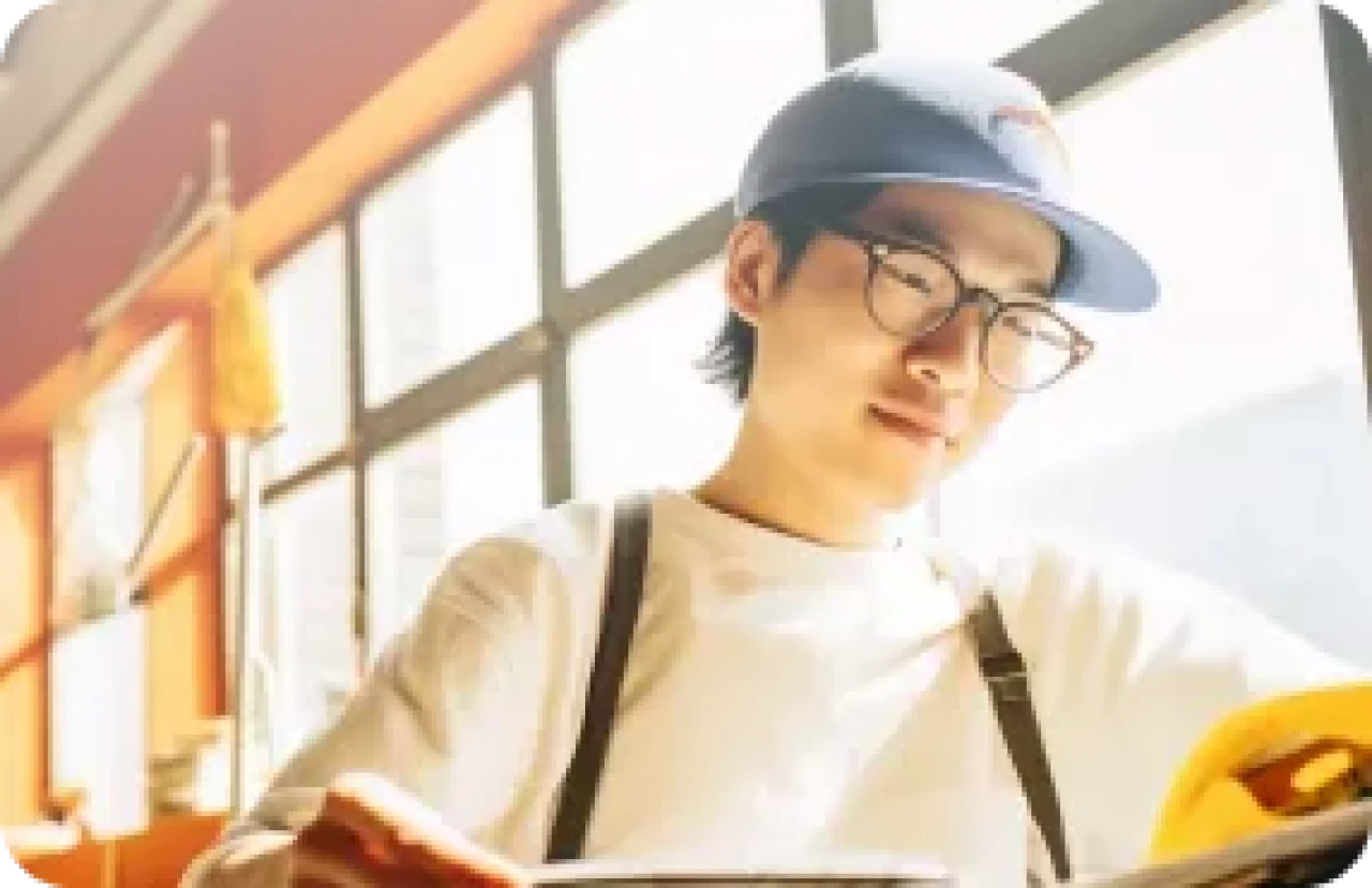 Young Student Studying In Coffee Shop With Natural Light