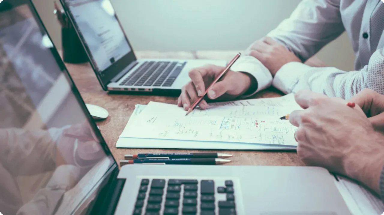 Person Holding Pencil Near Laptop