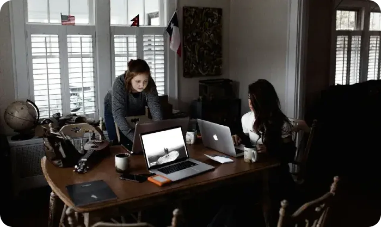 Two people working on laptops