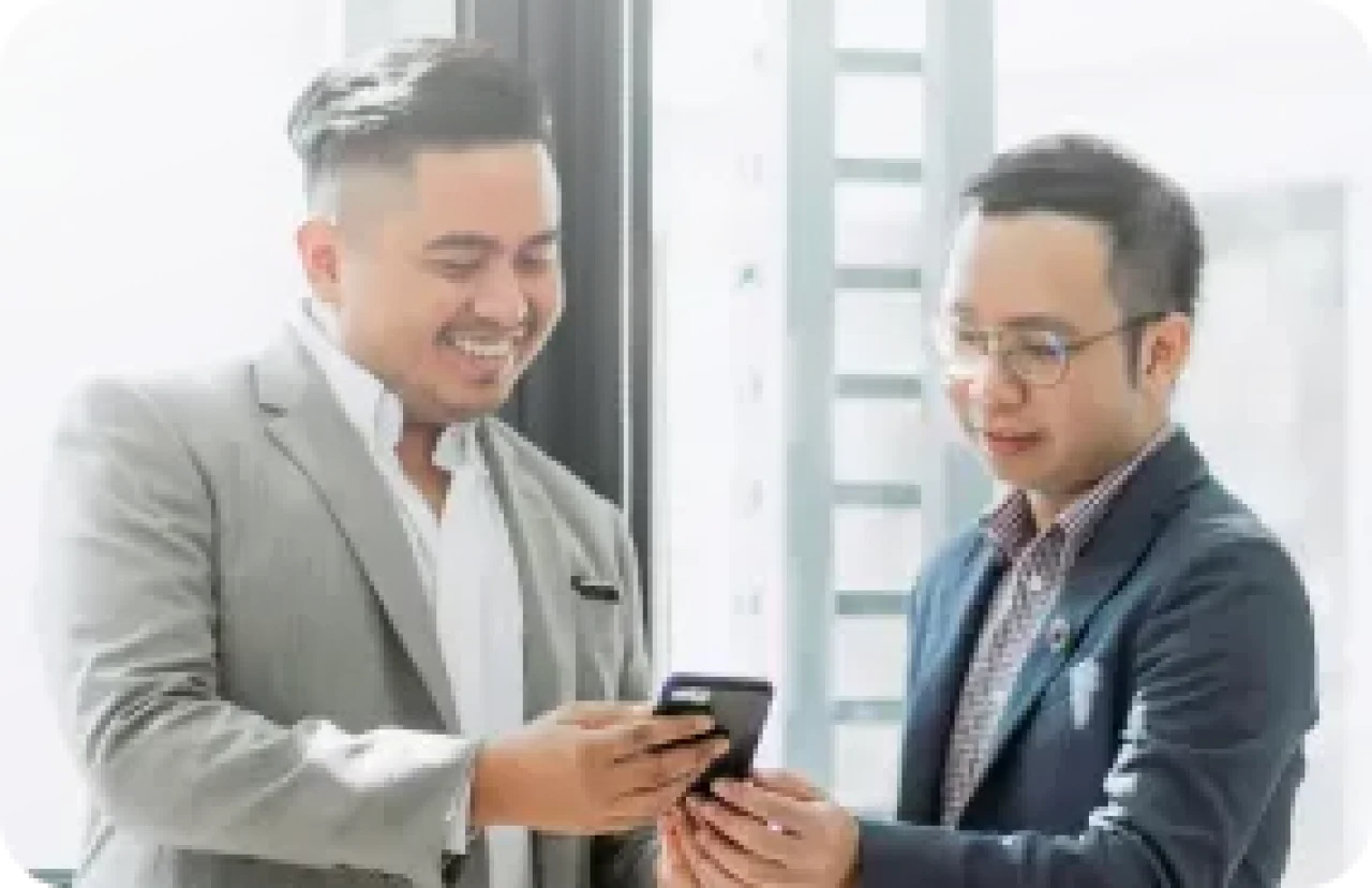 Business Meeting Two Men Sharing Information On Smartphone