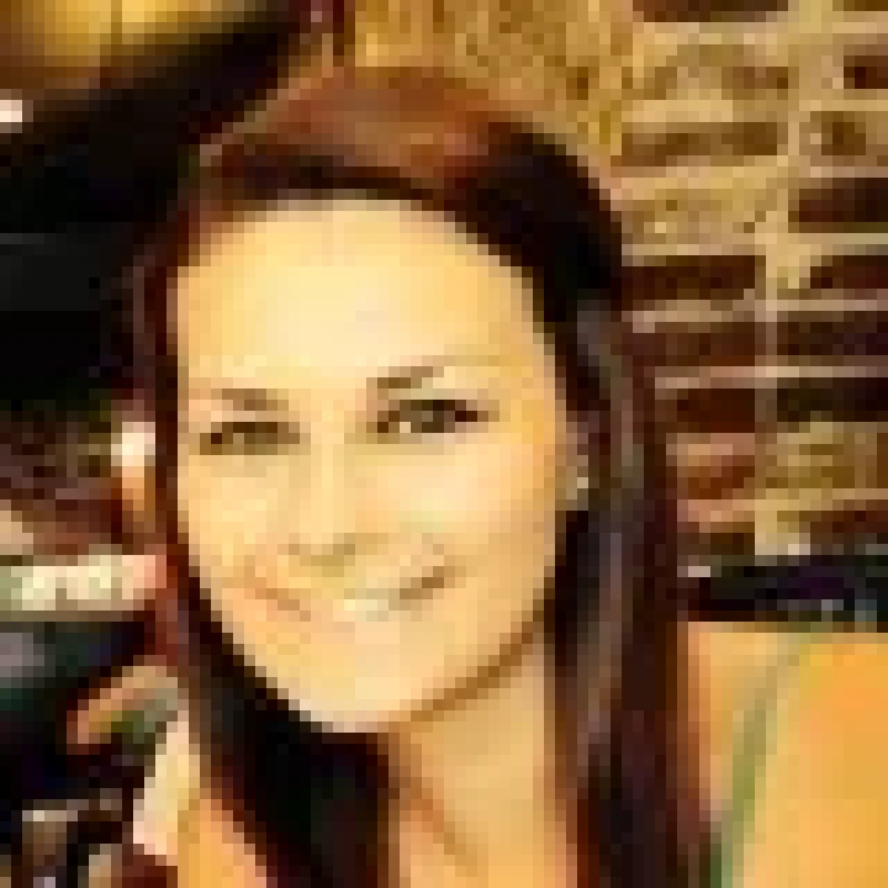 Lisa Crocco, smiling, wearing professional attire, with a neutral background