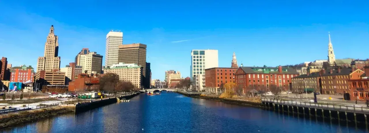 Providence skyline with historic and modern buildings along the river on a clear day.