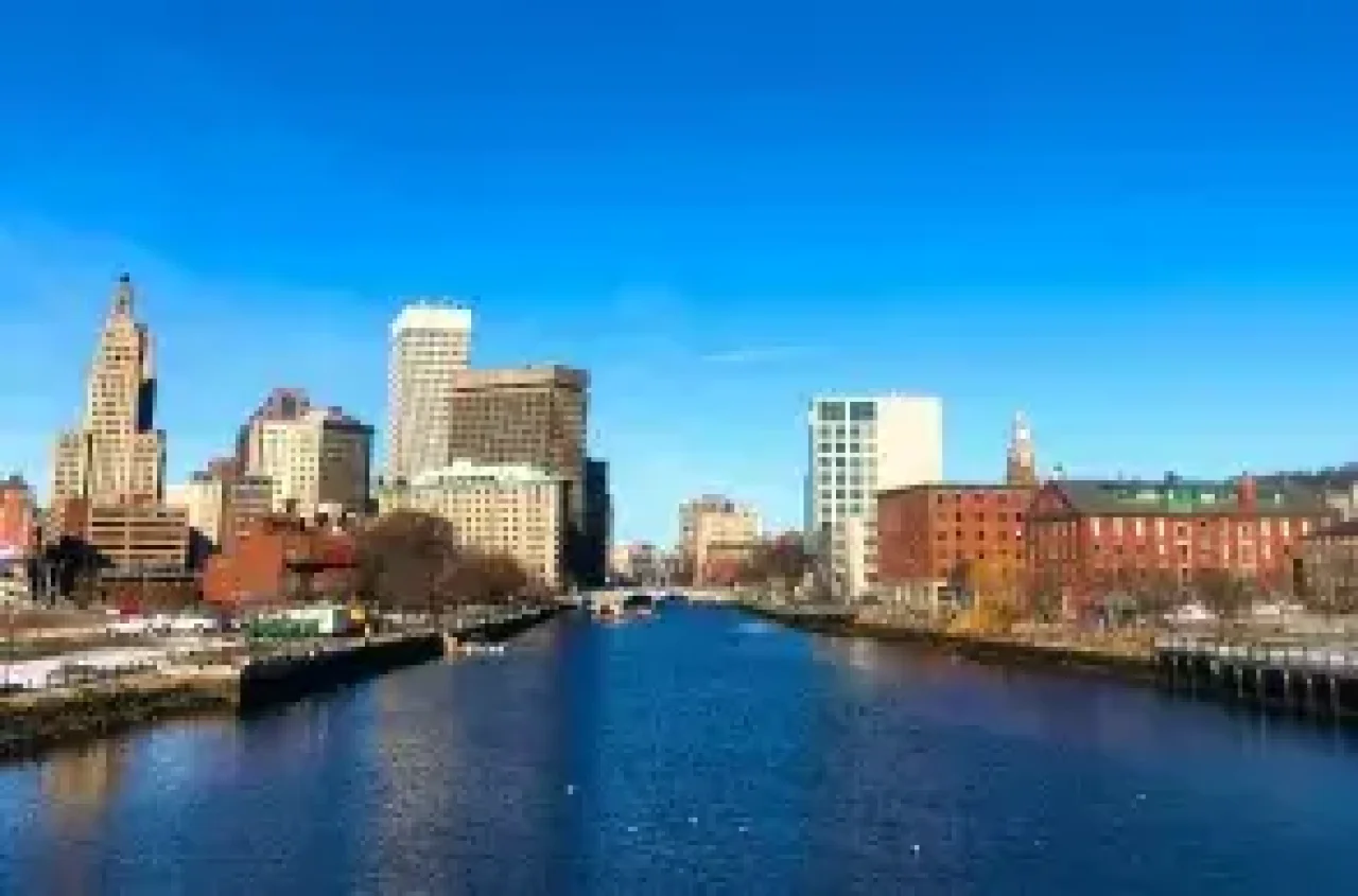 Providence skyline with historic and modern buildings along the river on a clear day.